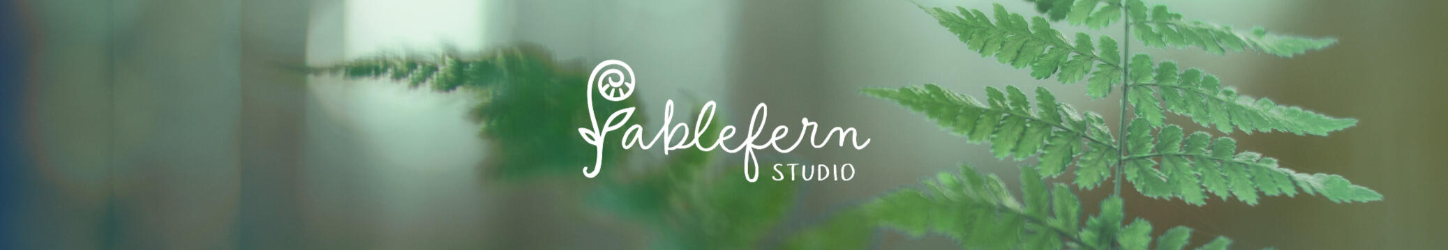 Fablefern Studio Header Fablefern Studio logo over a fern background.